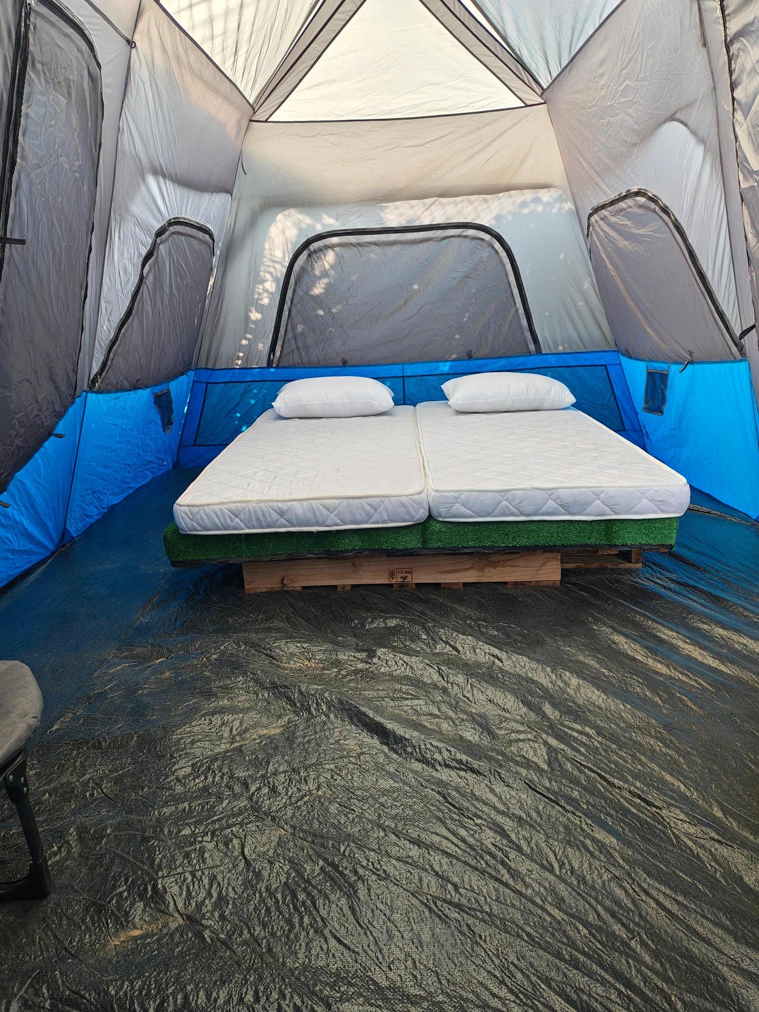 Inside a Deluxe 4 tent: a double bed made up with pillows