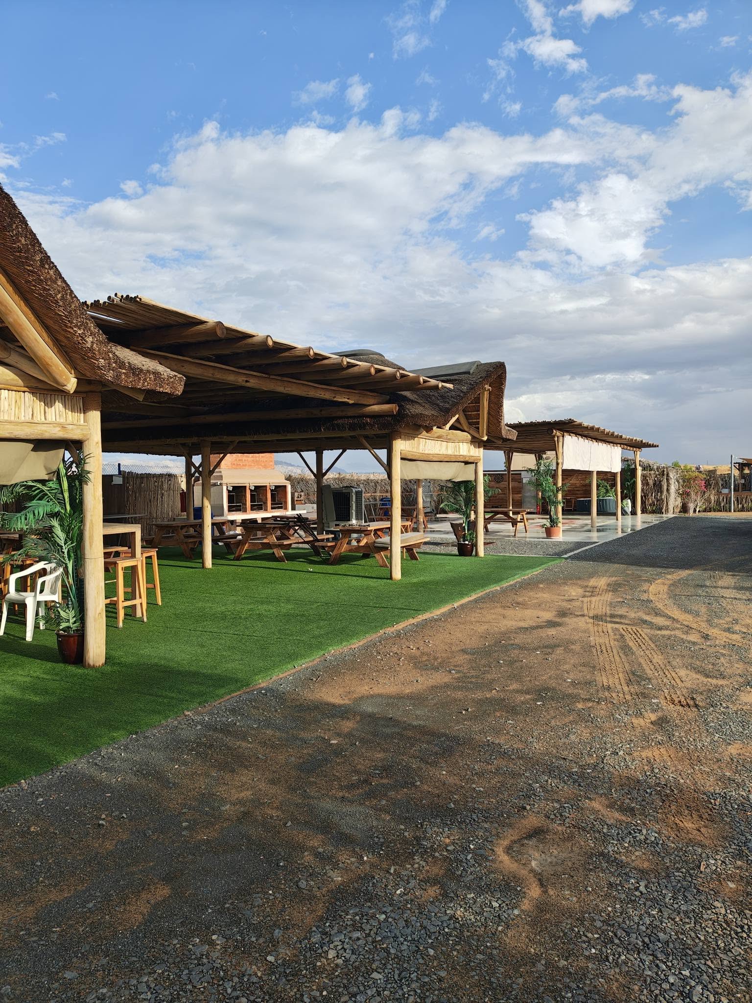 Shaded seating on the grass beside the camp road